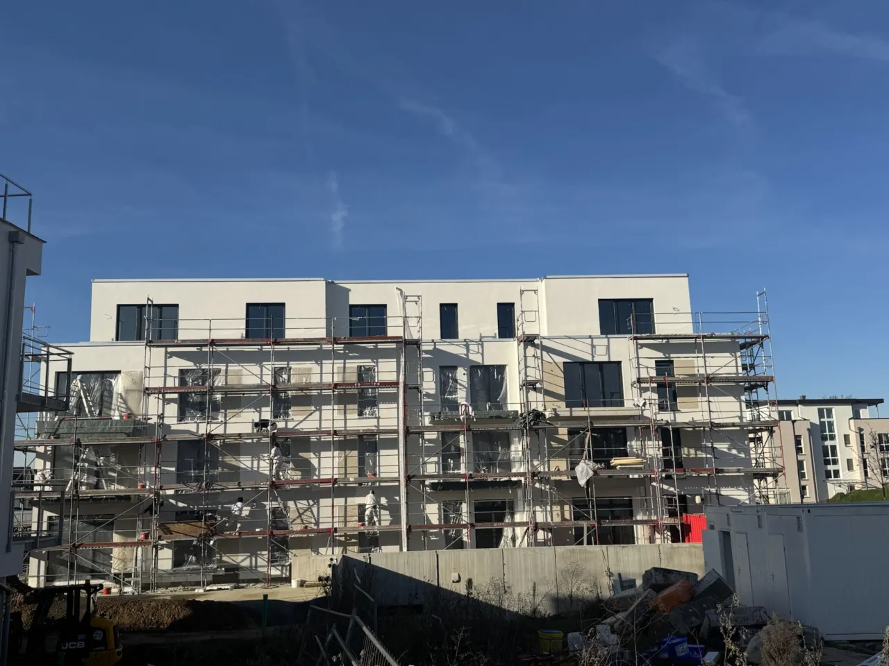 Fassade eines Mehrfamilienhauses mit Gerüst während der Fassadenarbeiten